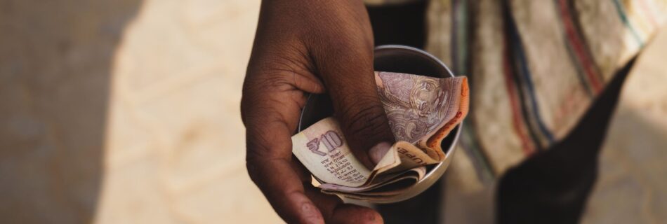 A close-up of a hand holding Indian currency notes, highlighting economic themes.