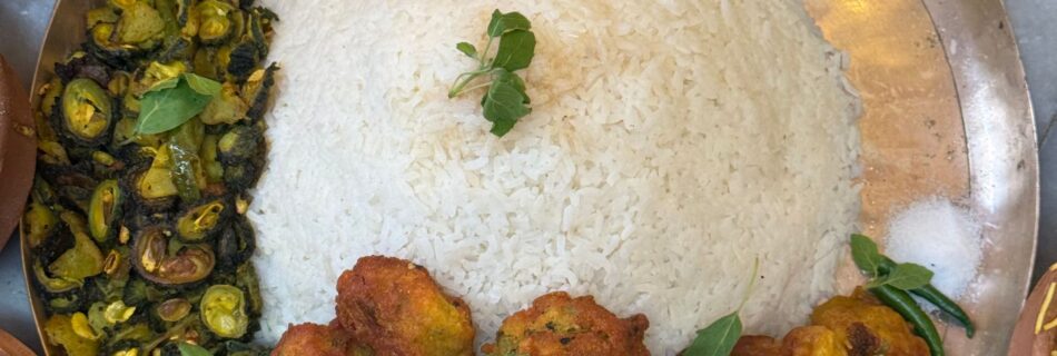 An appetizing traditional Nepali thali featuring rice, vegetables, and curry dishes arranged on a metal plate.