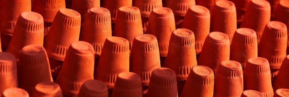 Brightly colored terracotta pots arranged in rows showcasing texture and vibrant colors.