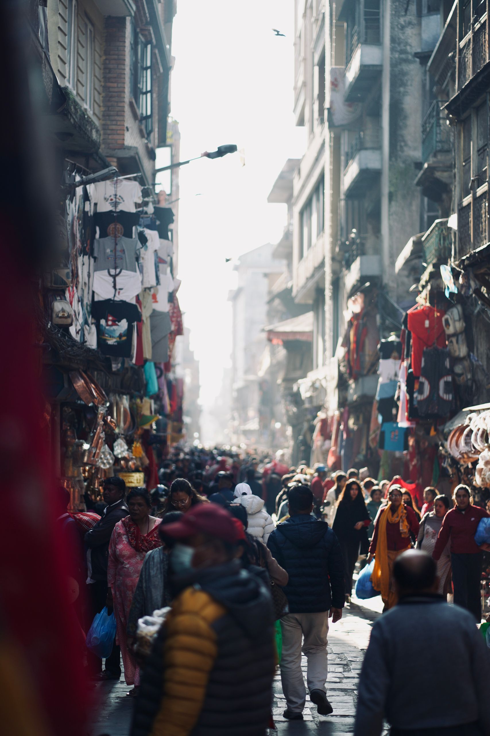 Vibrant and chaotic street scene in Nepal bustling with people and market stalls.