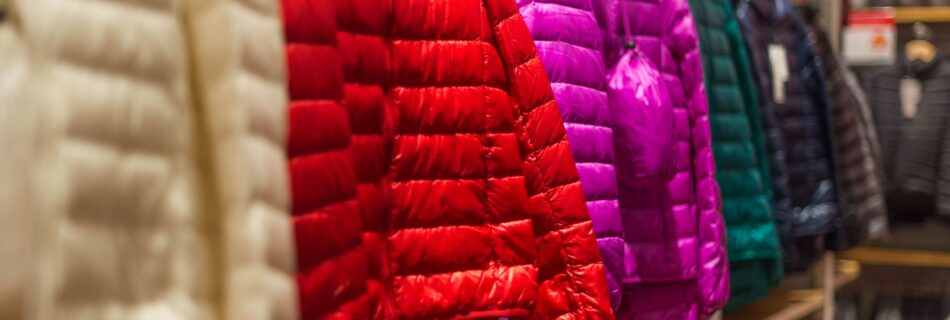 Vibrant winter jackets on display in a clothing store, showcasing a variety of colors for shoppers.